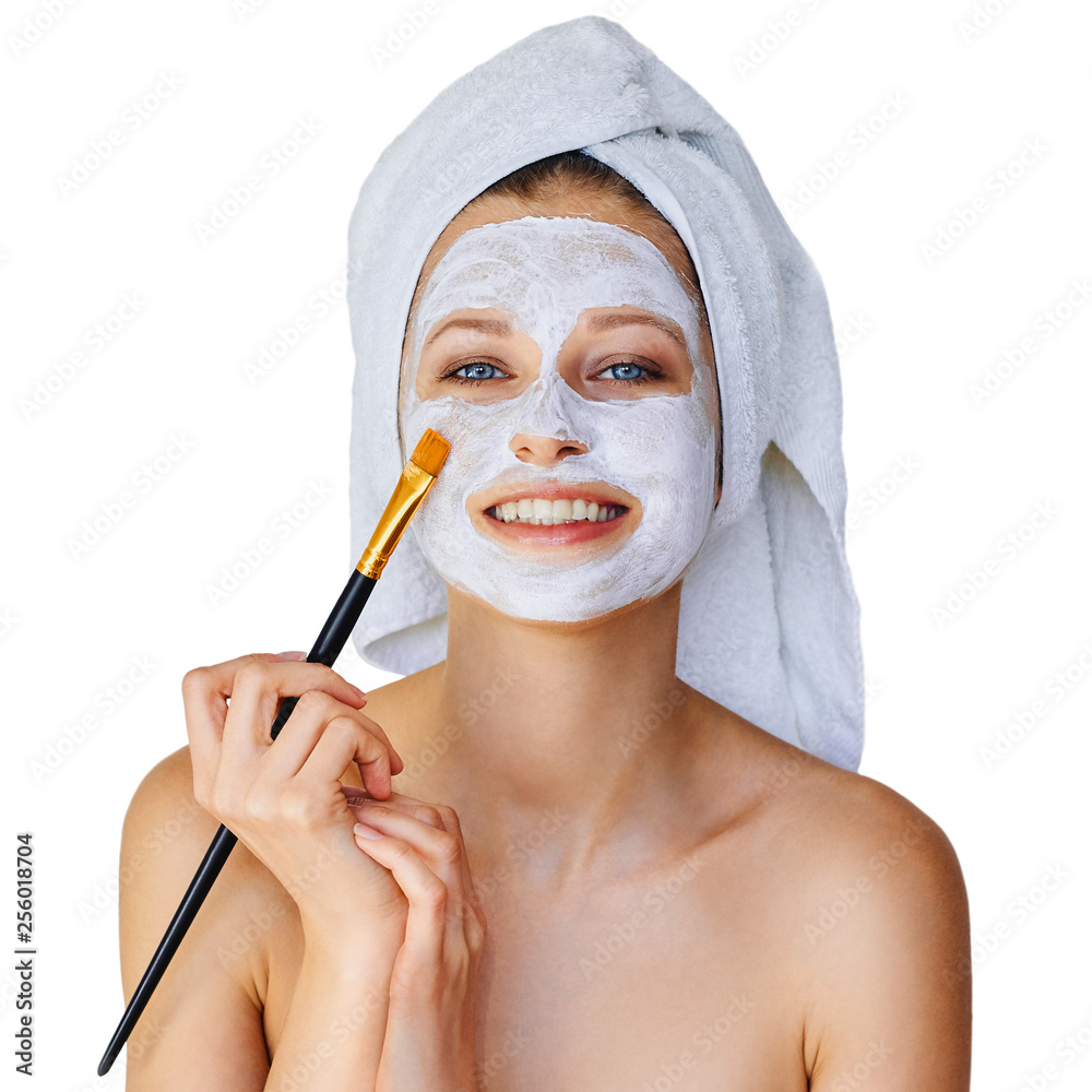 Beautiful young woman applying facial mask on her face with brush. Skin  care and treatment, spa, natural beauty and cosmetology concept, isolated  over white background Stock-Foto