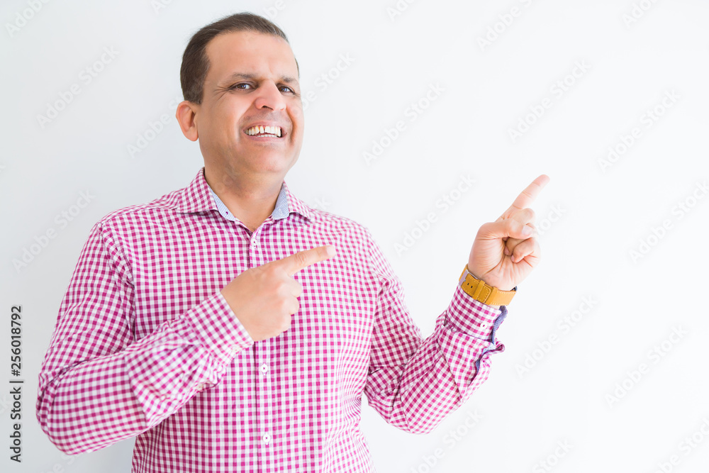 Middle age man wearing business shirt over white wall smiling and looking at the camera pointing with two hands and fingers to the side. Middle age man wearing business shirt over white wall smiling and looking at the camera pointing with two hands and fingers to the side.