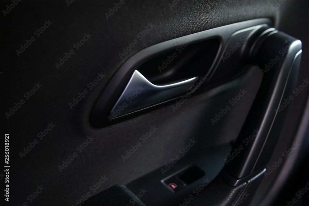 the handle of the door opener in the car. silver handle on the black panel in the car the handle of the door opener in the car. silver handle on the black panel in the car