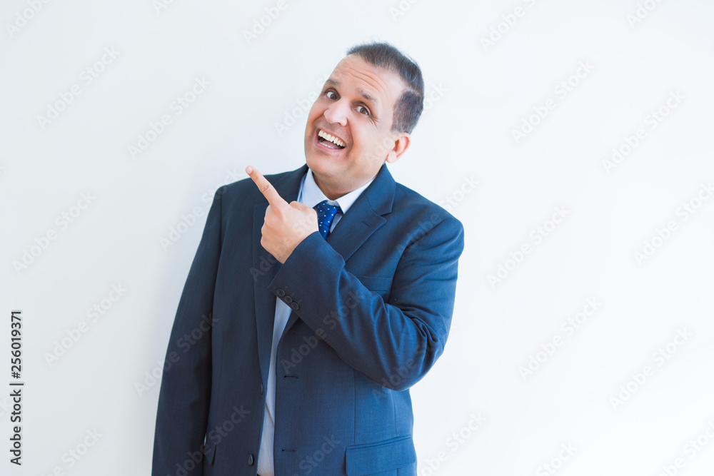 Middle age business man smiling and pointing to the side over white background
