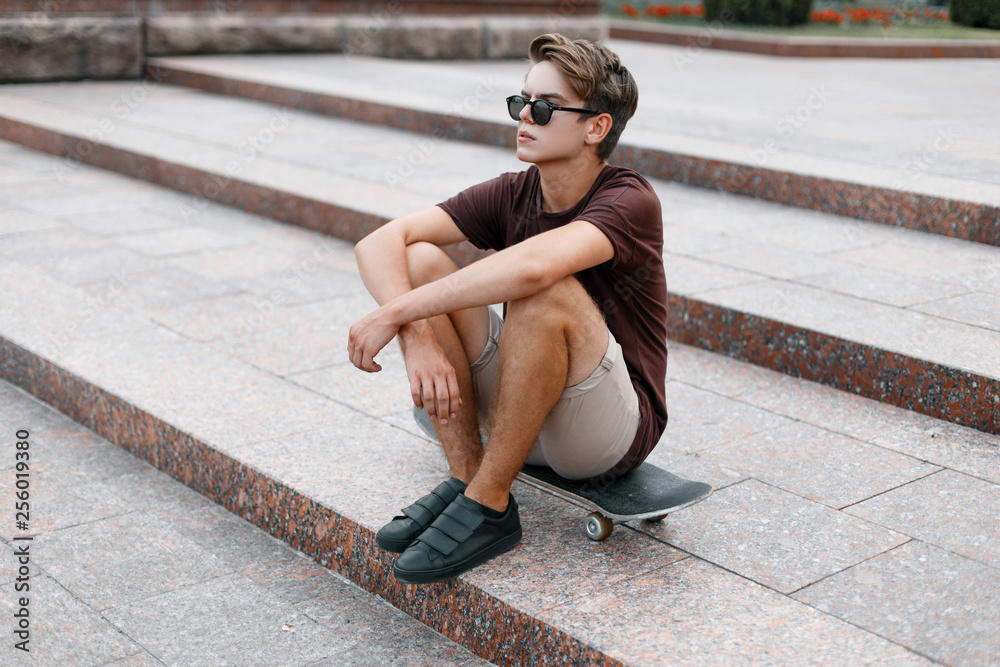 Young handsome hipster man in stylish sunglasses in stylish t-shirt in ...