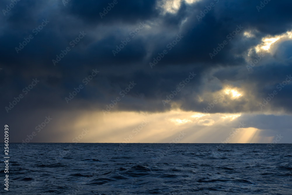 the sun shines through the storm clouds over the sea