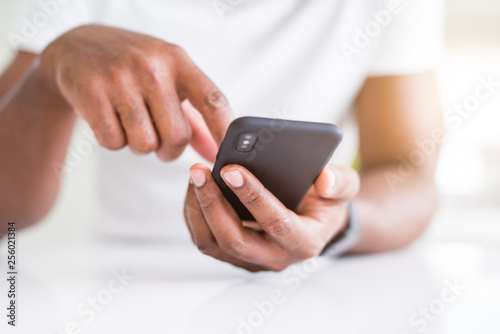 Close up of african american man hands using smartphone