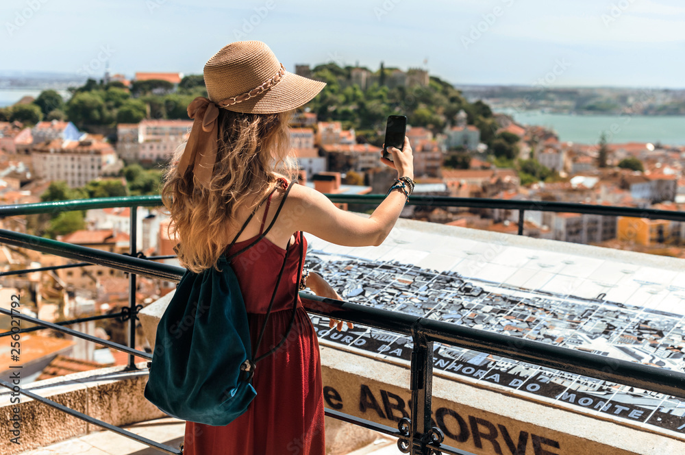 Young traveling woman walking on the streets of Lisbon city and looking at beautiful view