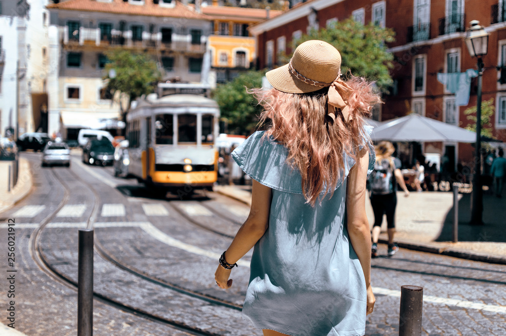 Εκτύπωση καμβά Young traveling woman walking on the streets of Lisbon city and looking at beaut