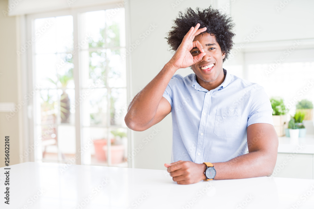 African American business man doing ok gesture with hand smiling, eye looking through fingers with happy face. African American business man doing ok gesture with hand smiling, eye looking through fingers with happy face.