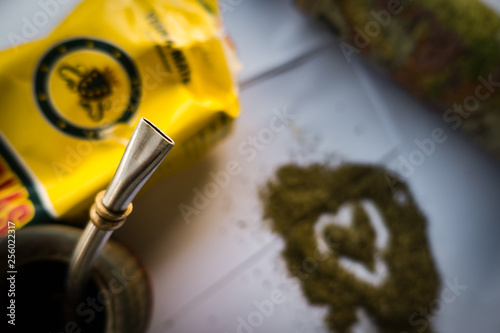 Traditional South American Yerba Mate tea in wooden mate cup with bombilla metal straw serving as a sieve. photo