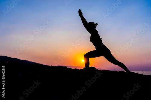 Wallpaper Mural Silhouette of a young woman doing yoga on the beach at sunset. Torontodigital.ca