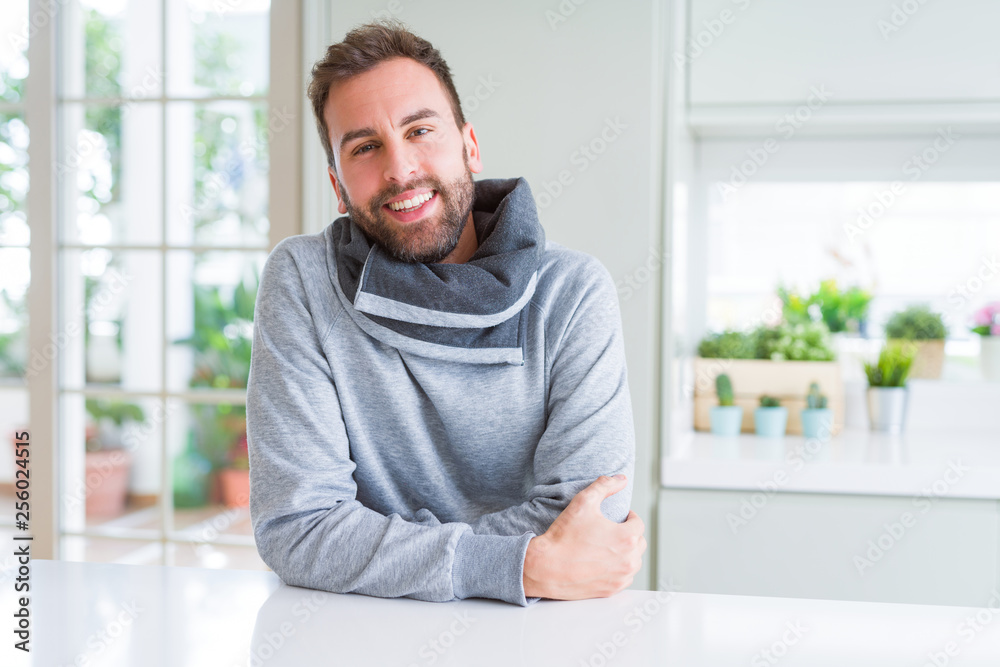 Handsome man wearing casual sweatshirt at home and smiling positive Handsome man wearing casual sweatshirt at home and smiling positive