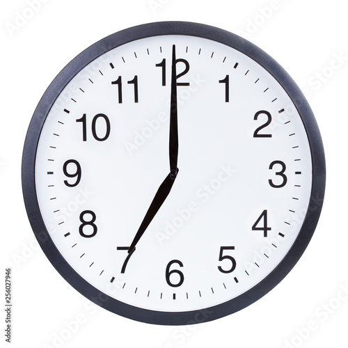 Round office clock showing seven o'clock isolated on white background
