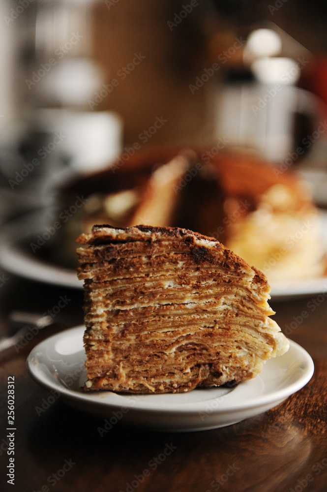 Φωτογραφία Piece of crepe cake with tiramisu filling and powdery cocoa is served on plate