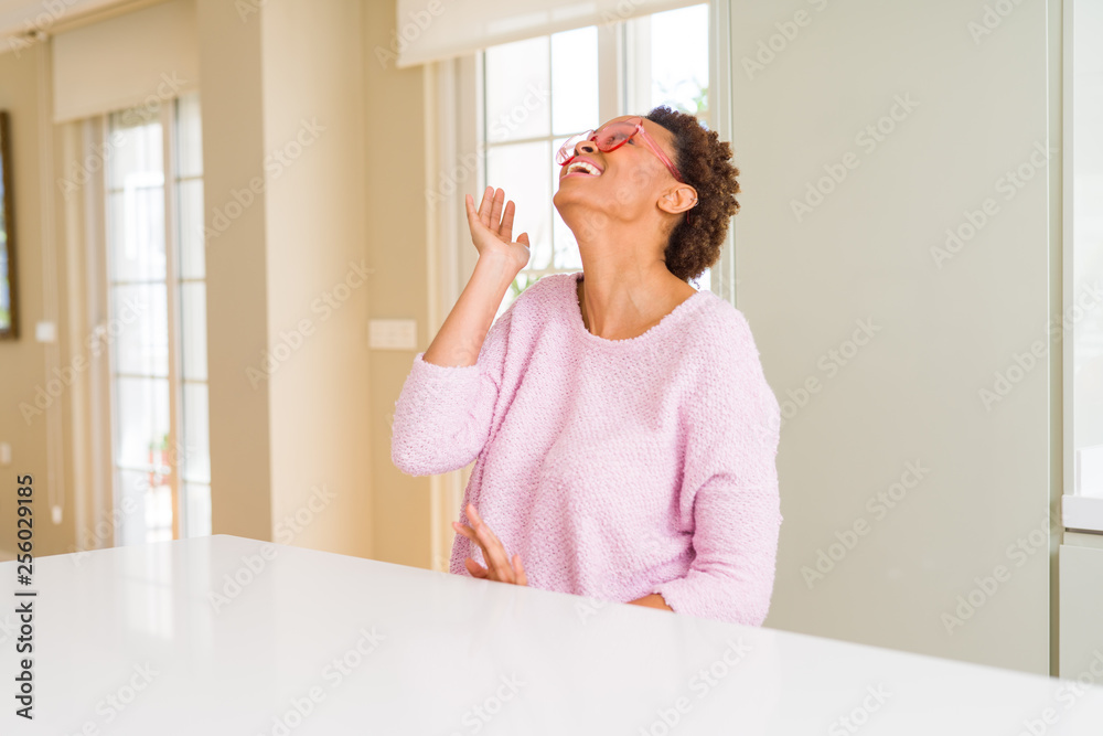 Beautiful young african woman with afro hair wearing funny pink heart glasses Beautiful young african woman with afro hair wearing funny pink heart glasses