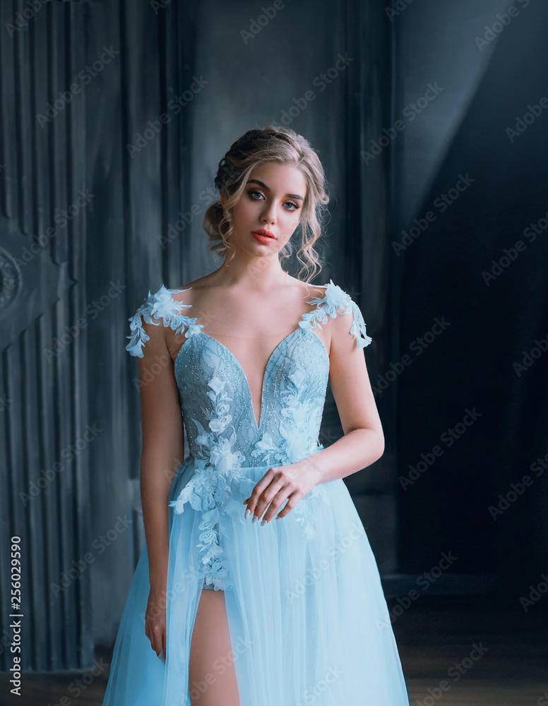 Φωτογραφία charming pretty lady with a light fluffy blue dress, magnificent detailed gown tailoring, excellent work of a photographer and make-up artist, a princess costume with a bare leg in the cut