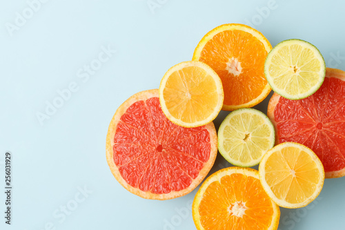 Colorful sliced fruits on blue background with copy space