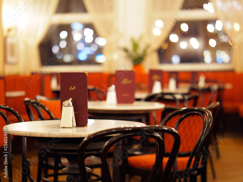 Kaffeehaus - Tische und Sessel mit Speisekarten und Zuckerspendern	