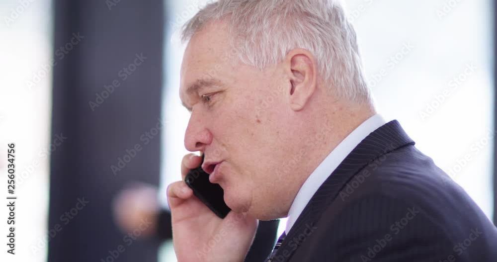 4K Close up of happy grey haired businessman talking & laughing on phone call 4K Close up of happy grey haired businessman talking & laughing on phone call