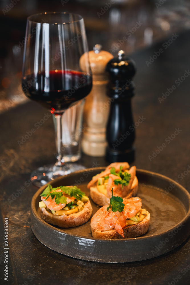 Avocado and shrimp bruschetta at table in the wine bar Avocado and shrimp bruschetta at table in the wine bar