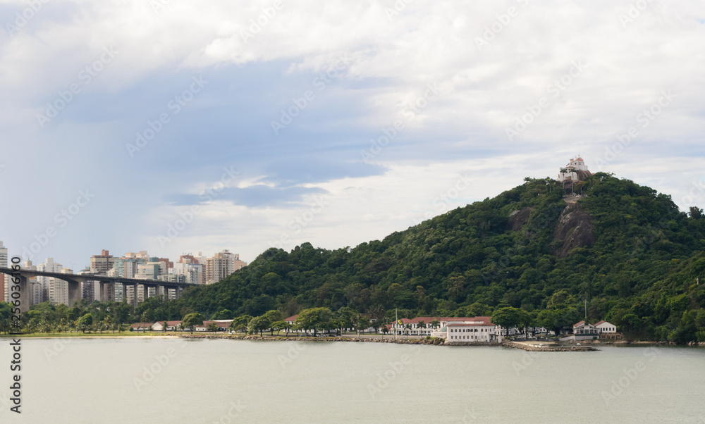 Obraz premium Aerial view of the beautiful city of Vitoria, Espirito Santo, Brazil and its wide bay. The city developed with its high buildings growing on the hills and into the local greenery