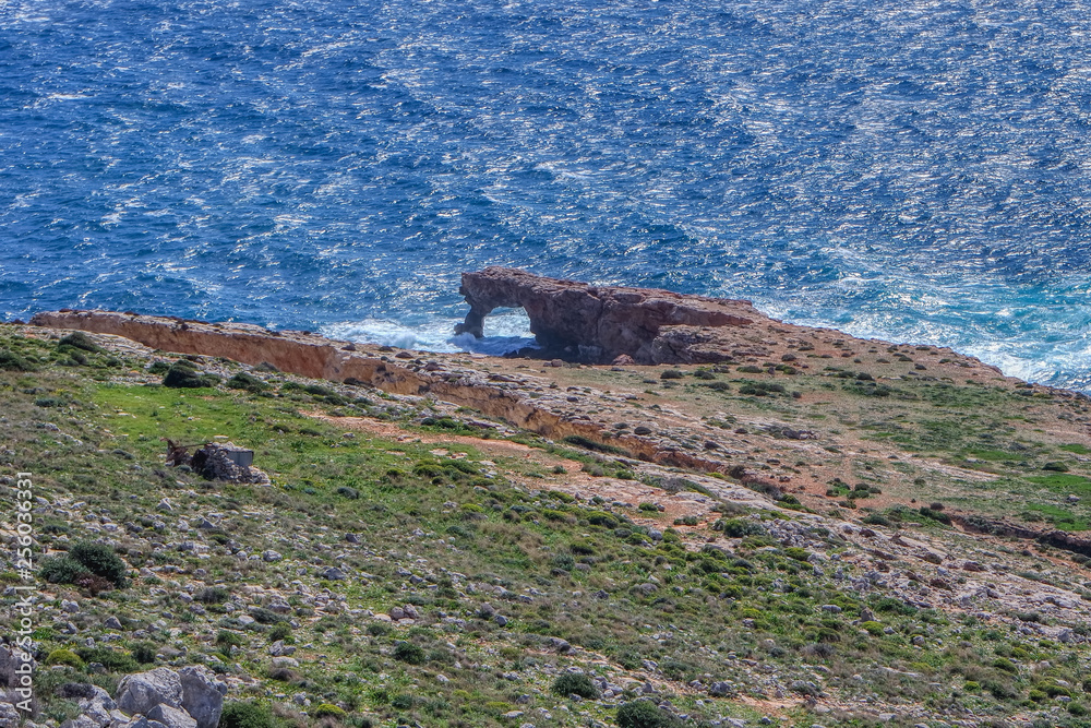 A natural rock arch Ras il-Hamrija (Ghar Hanex) feature is located below Mnajdra Temples in Qrendi, Malta