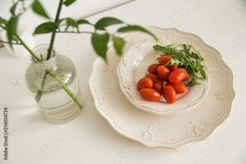 tomatoes and greens on the white table