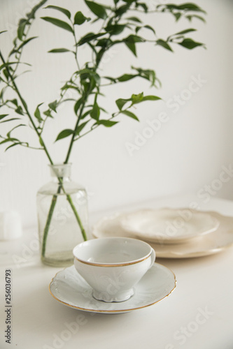 white cup and saucer on white table