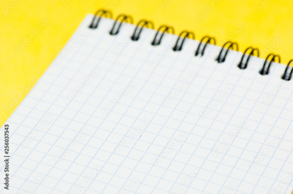 Blank sheet of a notebook (squared), on yellow background Blank sheet of a notebook (squared), on yellow background