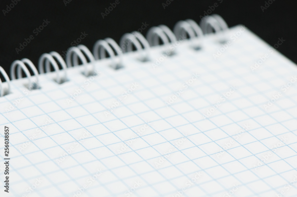 Blank sheet of a notebook (squared), on black background Blank sheet of a notebook (squared), on black background