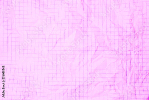 One crumpled pink blank paper sheet of a notebook in grid (background)