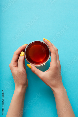 Hands holding a glass of tea