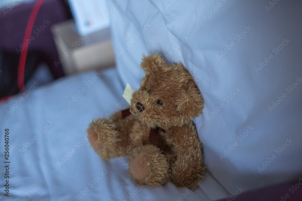 Teddybär sitz auf dem Bett