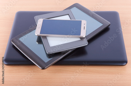 Stack made from notebook, tablet, ebook reader and a smatphone on a desk