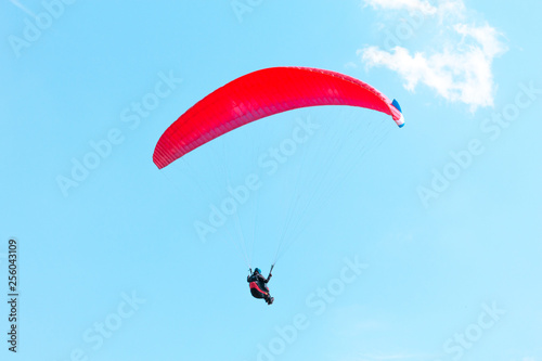 Flying paraglider on blue sky background