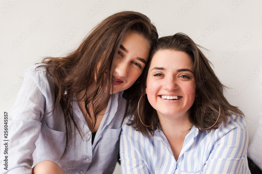 Portrait of two attractive women hugging in bed. Portrait of two attractive women hugging in bed.