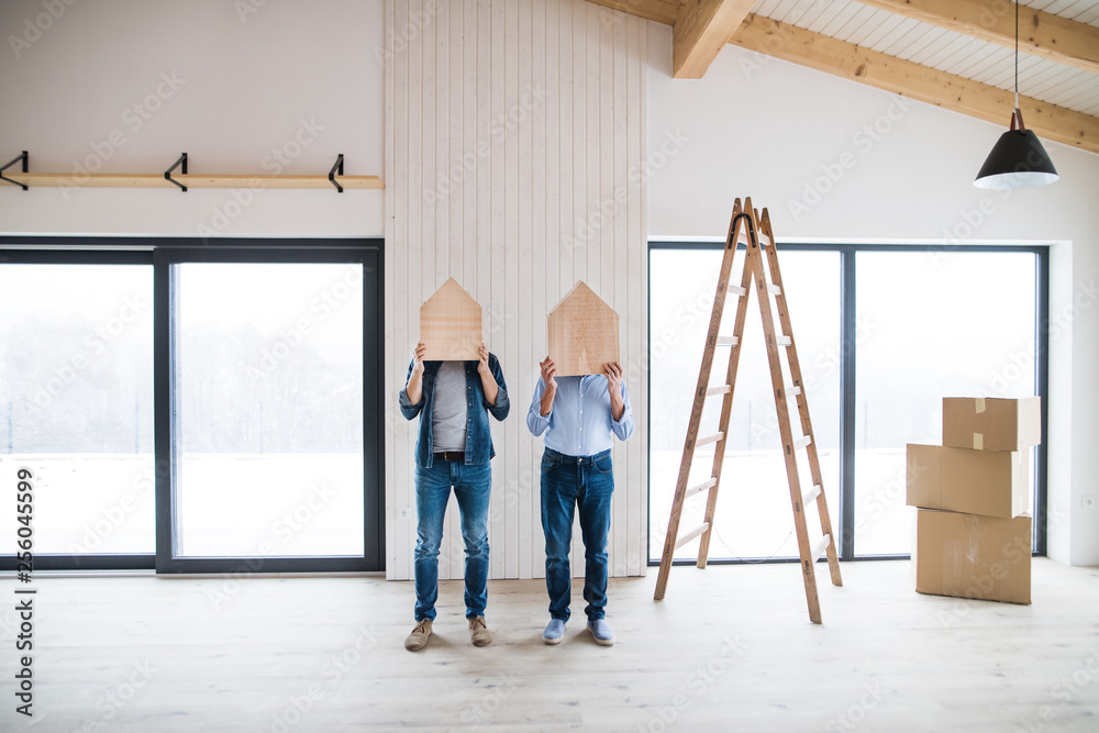 Men holding wooden houses on their heads when furnishing new house, a concept.