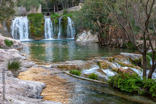 Fototapeta Naklejka Na Ścianę i Meble -  Waterfall with green water pond. Toll del Baladre, Las Fuentes del Algar / Algar fountains, Callosa de Ensarria, Alicante province, Spain.