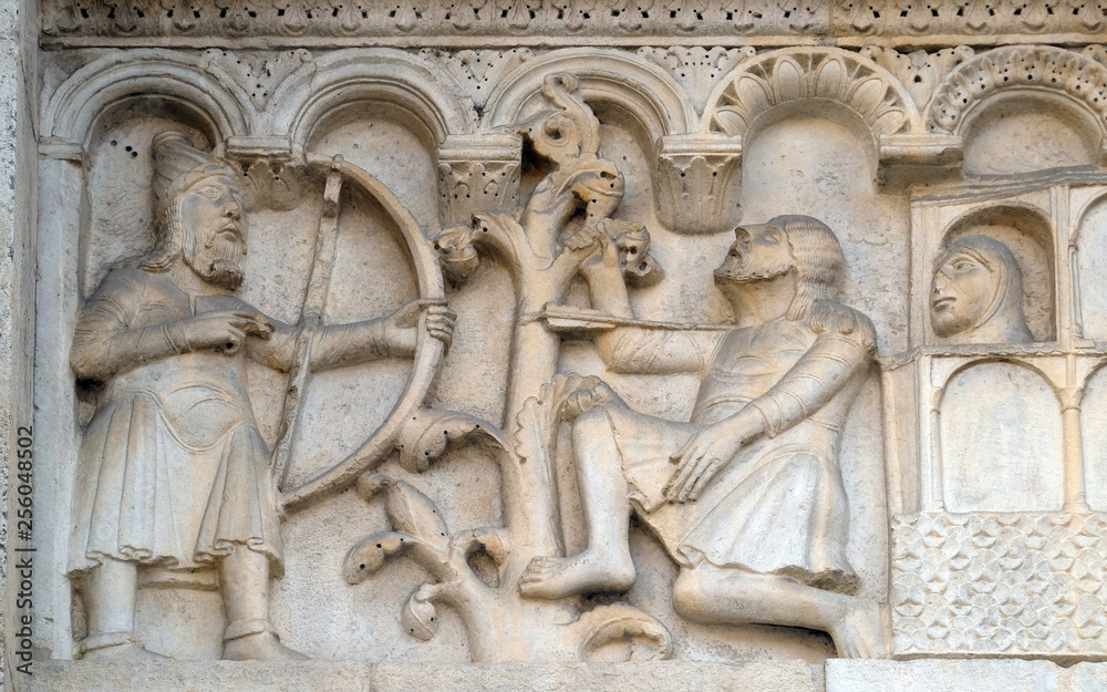 Obraz premium Plate with stories from Genesis: Blind Lamech kills Cain with an arrow in his throat, bass relief by Wiligelmo, Modena Cathedral, Italy