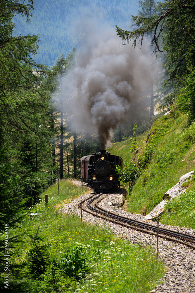 Alte Dampflokomotive fährt über den Furkapass in den Schweizer Alpen. Zahnradbahn in den Berge. Alte Dampflokomotive fährt über den Furkapass in den Schweizer Alpen. Zahnradbahn in den Berge.