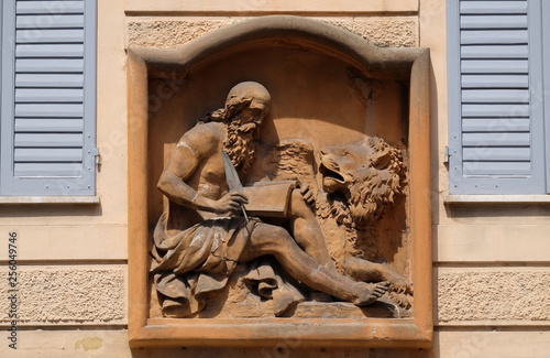 Saint Mark the Evangelist relief on house facade in Modena, Italy 