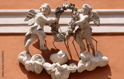 Symbols of Faith and Hope, statue on the portal of St. Barbabas Church, Italy photo