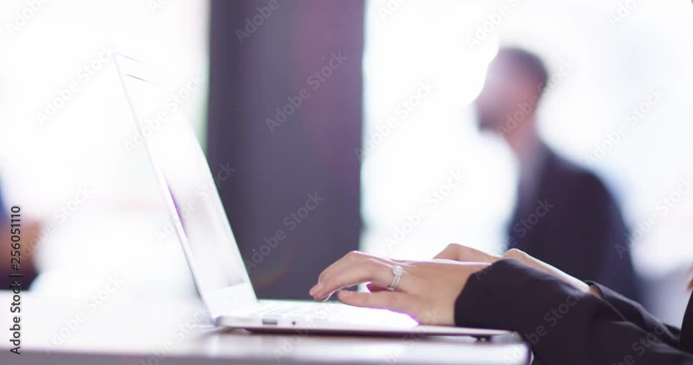 4K Closeup hands of businesswoman typing on laptop with colleagues in background 4K Closeup hands of businesswoman typing on laptop with colleagues in background