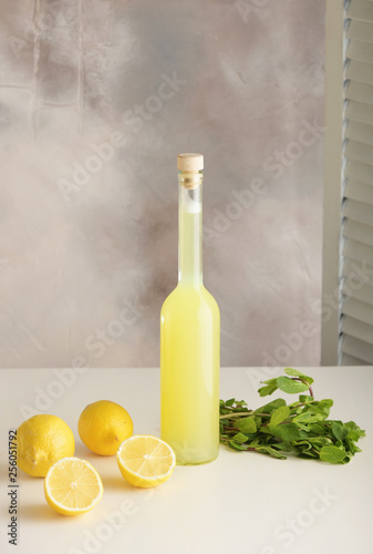 Bottle of homemade juice with mint and lemon on light background. Vertical