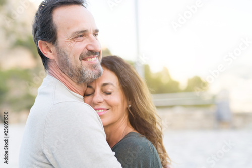Romantic couple smiling, cuddling and hugging on a sunny day
