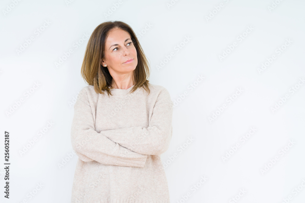 Beautiful middle age woman over isolated background smiling looking to the side with arms crossed convinced and confident Beautiful middle age woman over isolated background smiling looking to the side with arms crossed convinced and confident