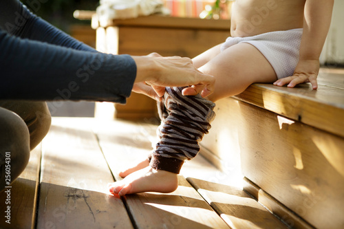 Mother helps toddler get dressed