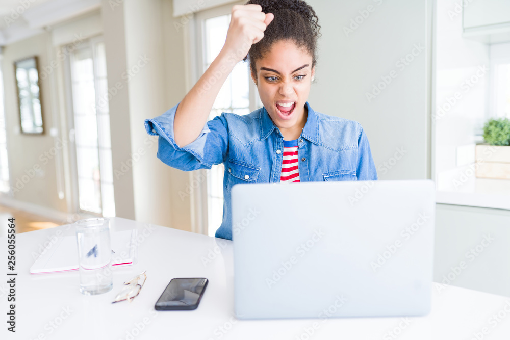 Young african american student woman using computer laptop annoyed and frustrated shouting with anger, crazy and yelling with raised hand, anger concept