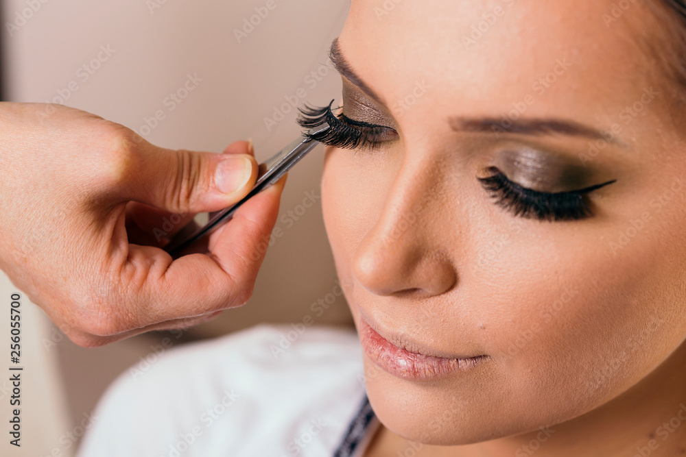 Make up artist placing artificial eyelashes