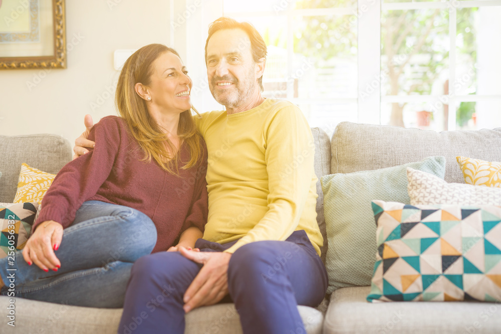 Middle age romantic couple sitting on the sofa at home