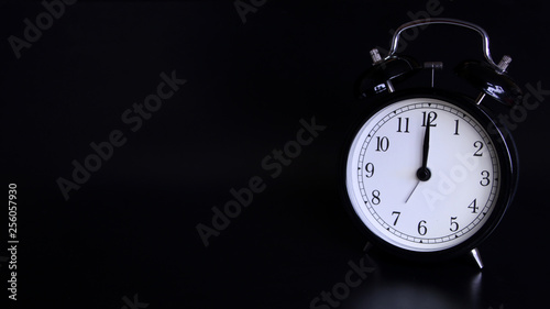 Close up image of old black vintage alarm clock. 12 o'clock