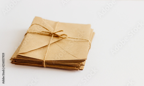 Mail kraft envelopes on white background, closeup. A stack of letters wrapped in twine.