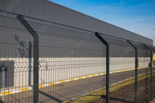 Obraz na płótnie Steel grating fence made with wire on blue sky background
